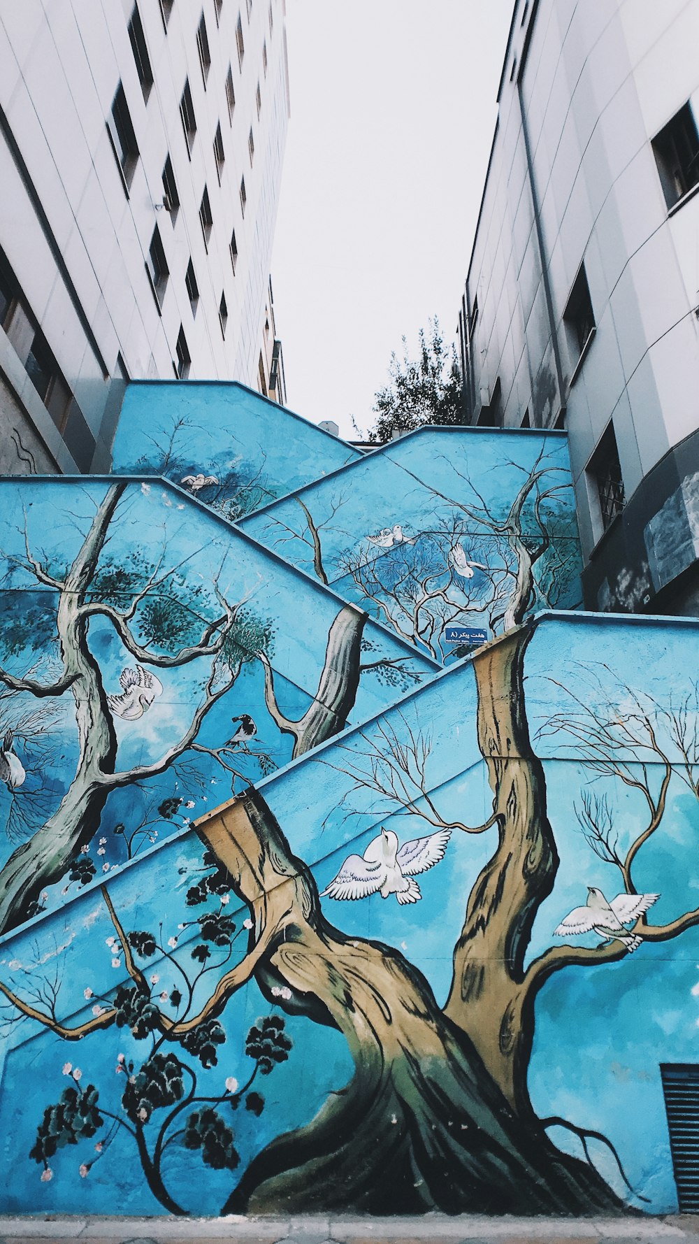pintura mural de árboles y pájaros azules y marrones