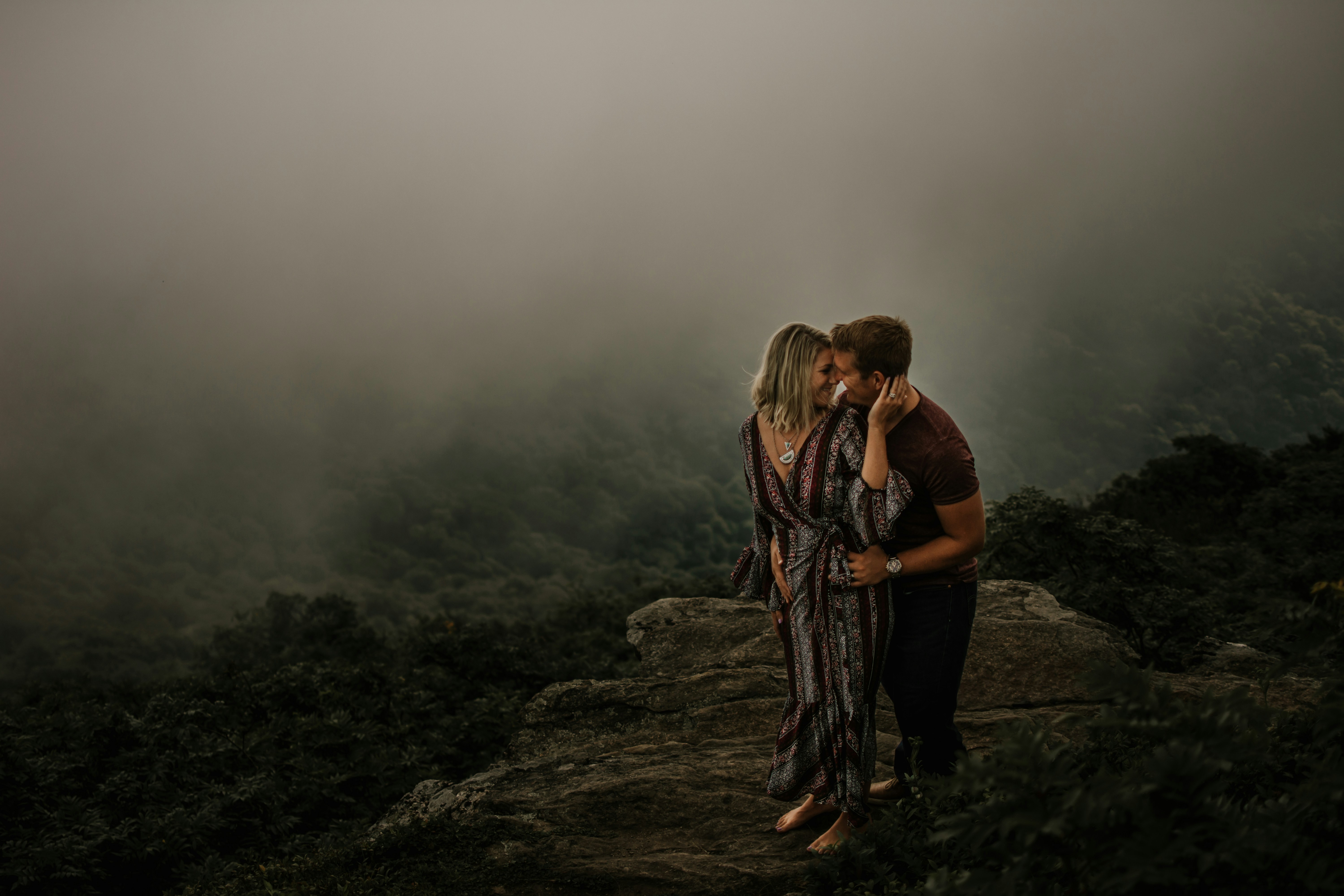 man and woman standing on top of mountain during daytime