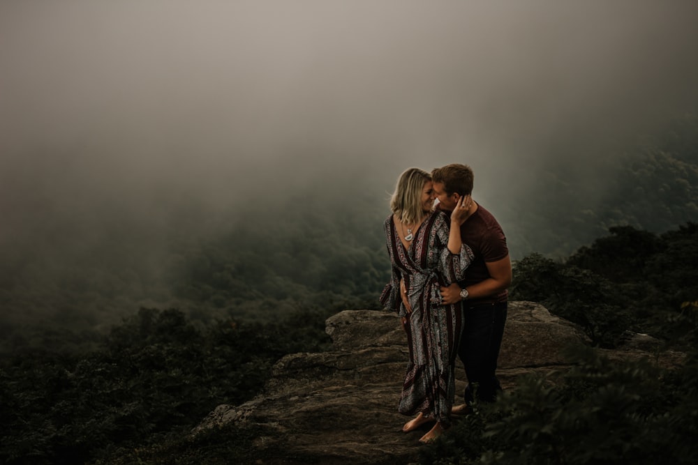 man and woman standing on top of mountain during daytime
