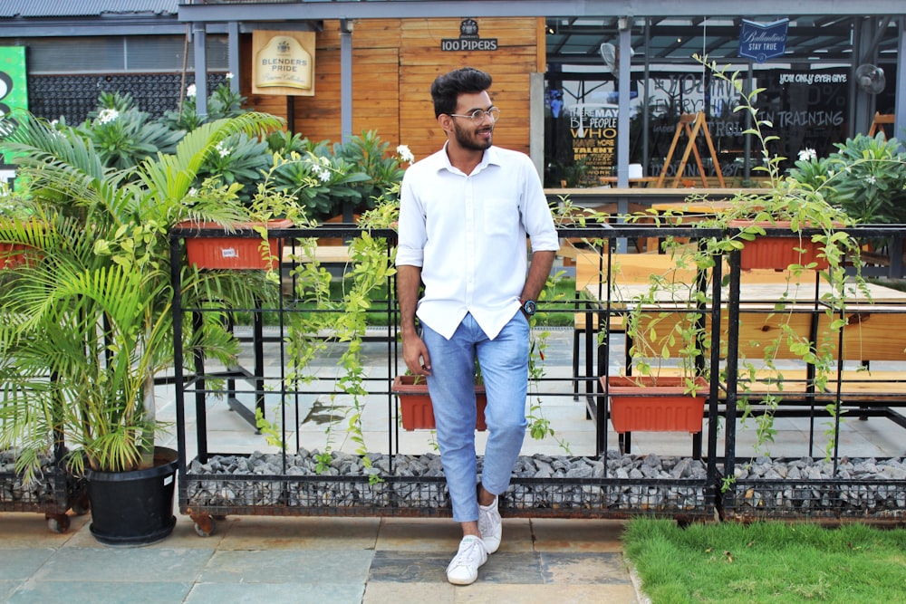 man leaning against a plant rack