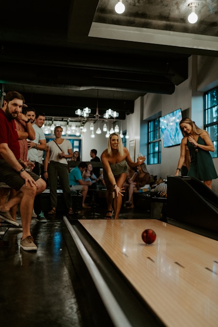 Group of college students bowling together at a brightly lit bowling alley