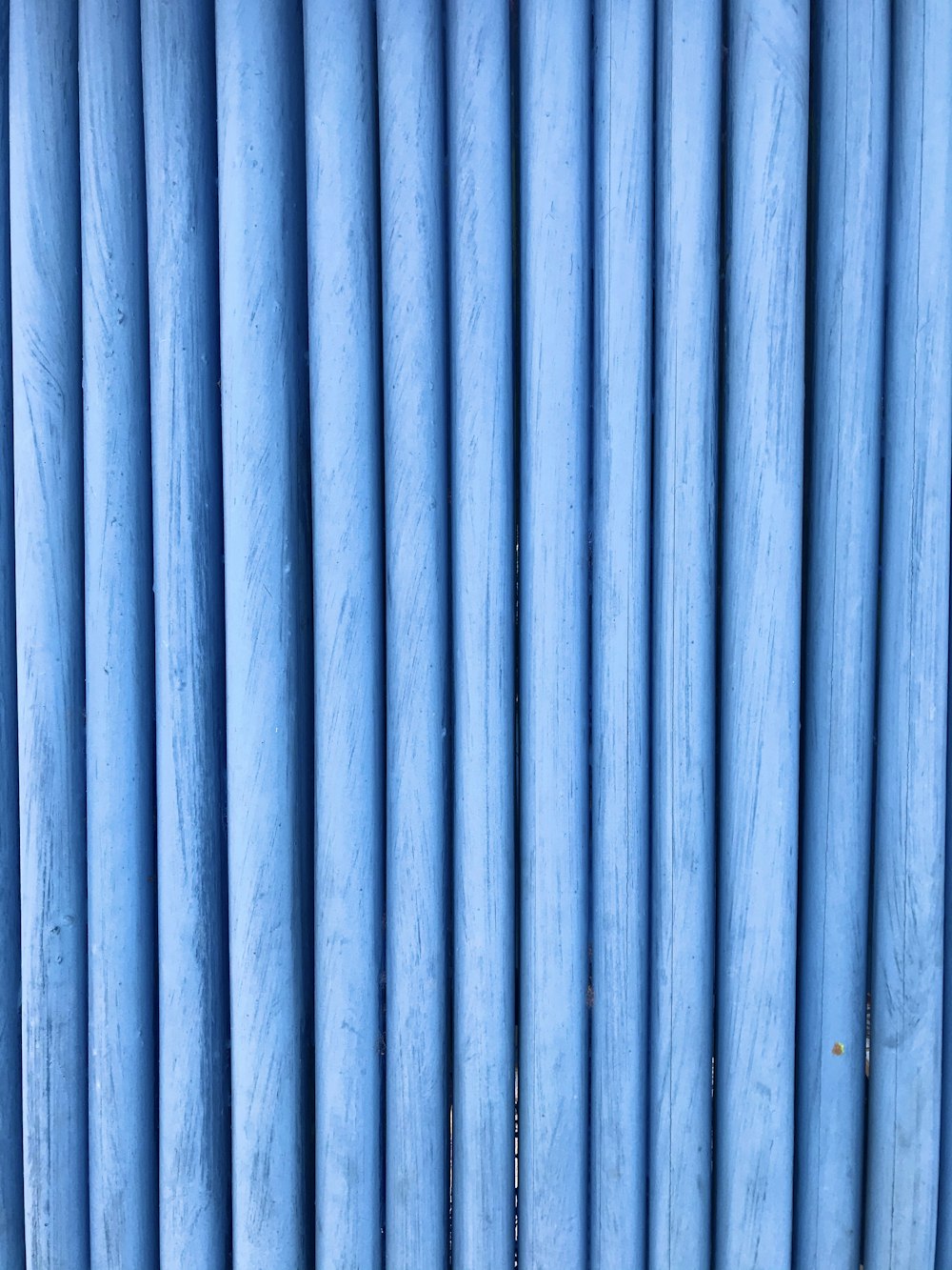 a close up of a wall made of blue pipes