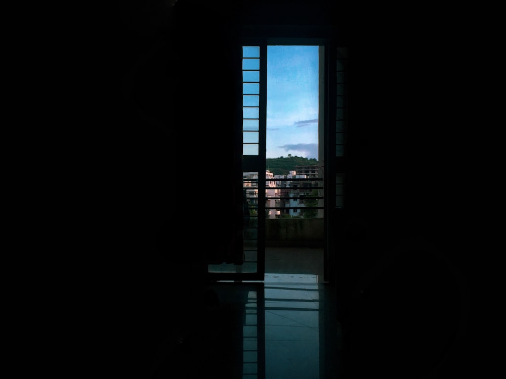 a dark room with a window and a view of a city