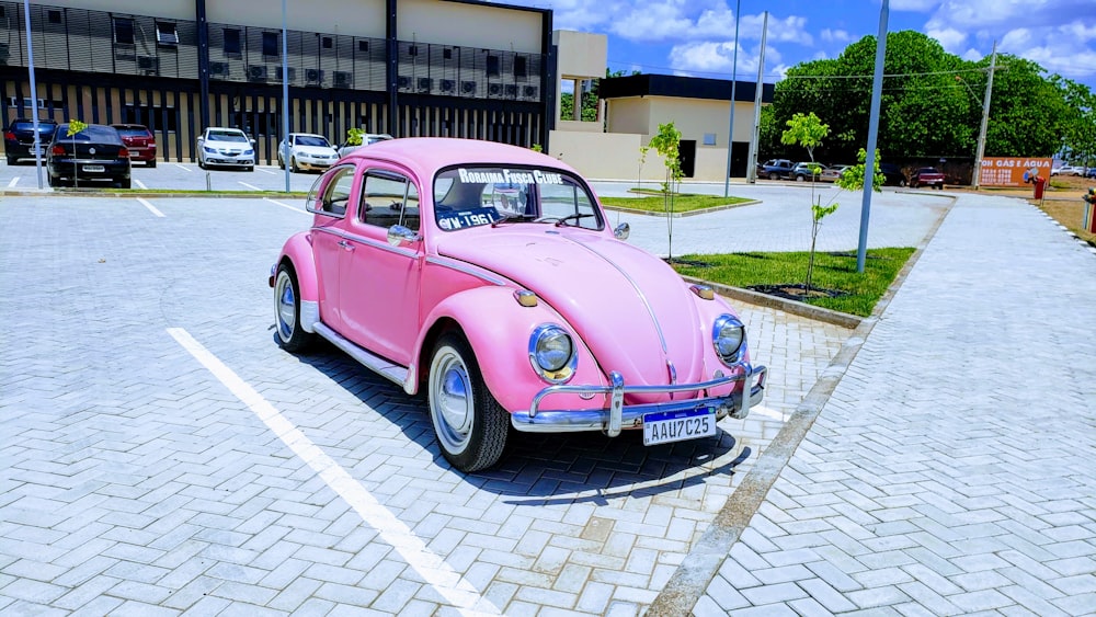 pink Volkswagen Beetle coupe parking near road during daytime