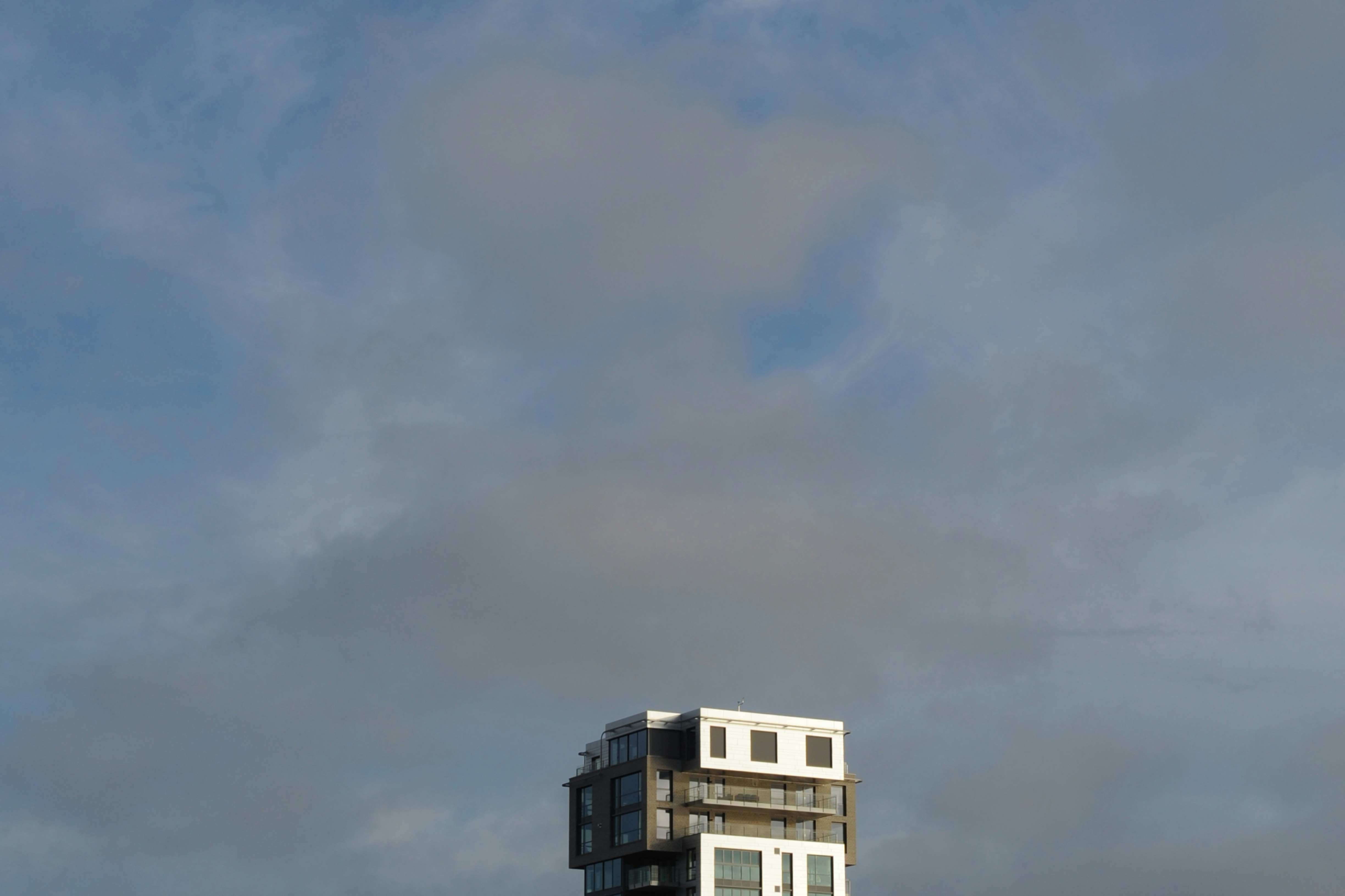 리버풀 대 에버턴 - white and gray concrete multi-storey building under a cloudy sky