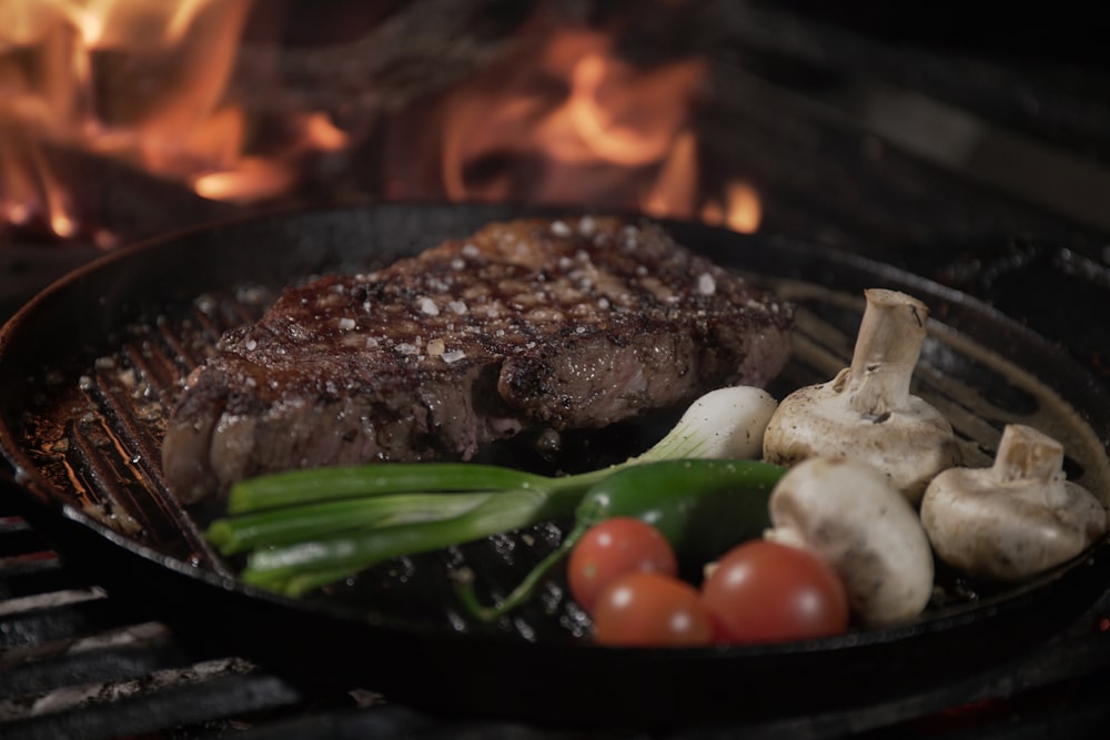 um bife e legumes cozinhando em uma grelha