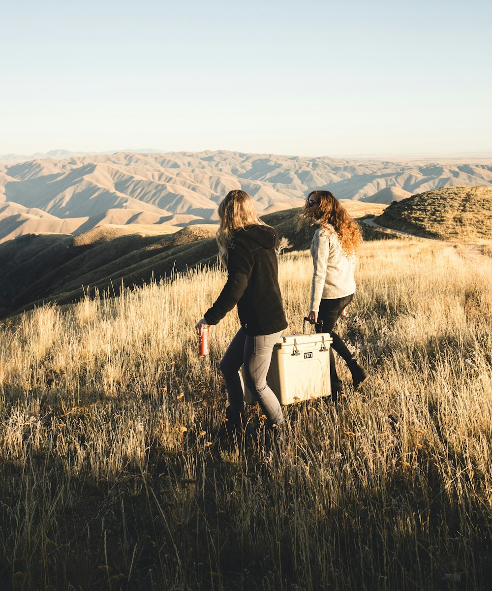 Dos mujeres que llevan una nevera portátil