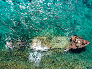 aerial photography of abandoned boat in body of water during daytime