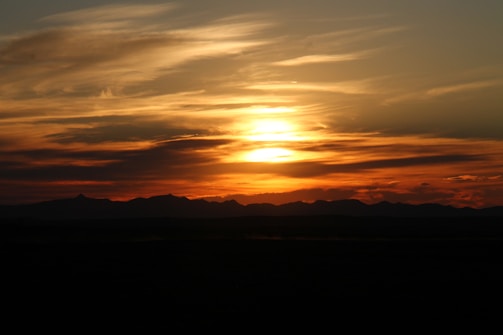 Sunset casting a golden glow over Moreno's Farm with the mountain silhouette in the background.