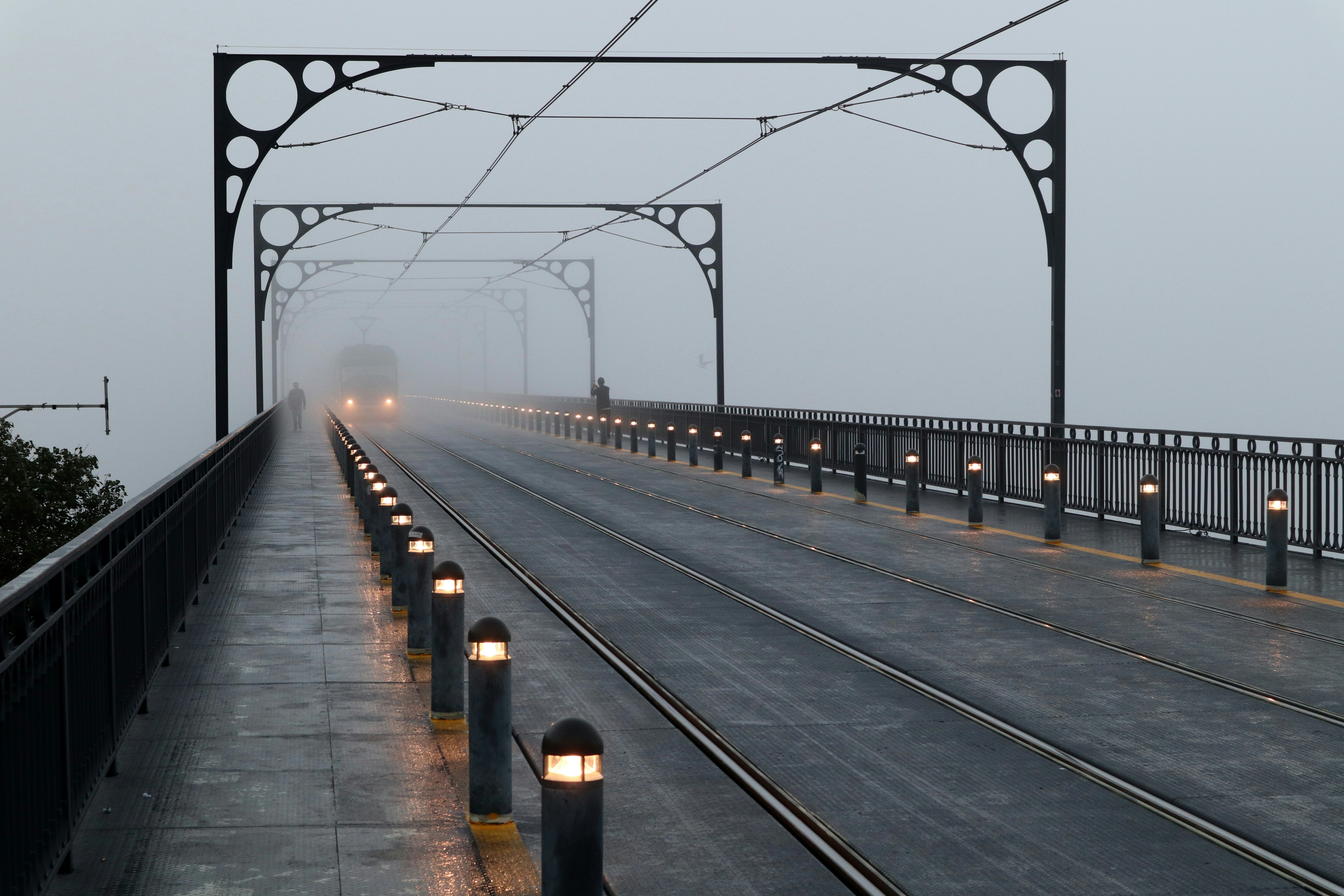 A quiet railway platform at dawn, empty tracks, soft fog, emotional and reflective mood