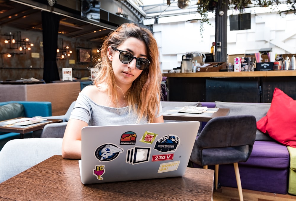 a woman sitting at a table with a laptop