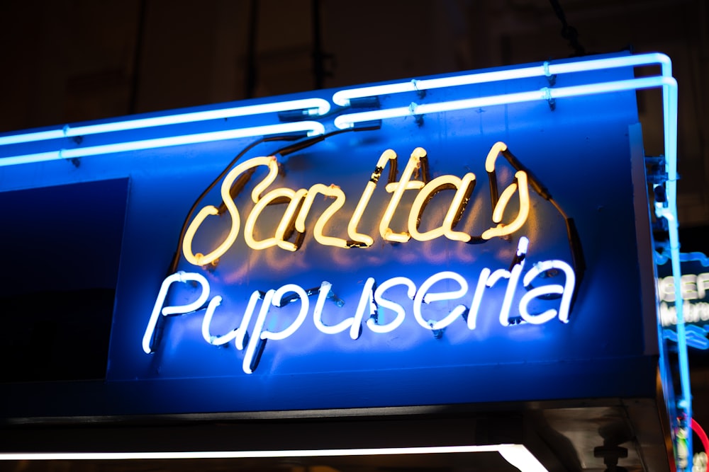 blue and beige Sarita's Pupuseria neon sign