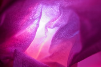 A close-up of a textured abstract digital painting with soft pink and gold accents.