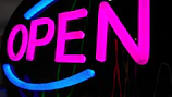An eye-catching open sign illuminated at night.