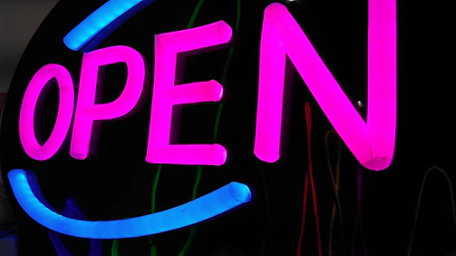 A vibrant, colorful signboard with bold lettering inviting customers to connect.