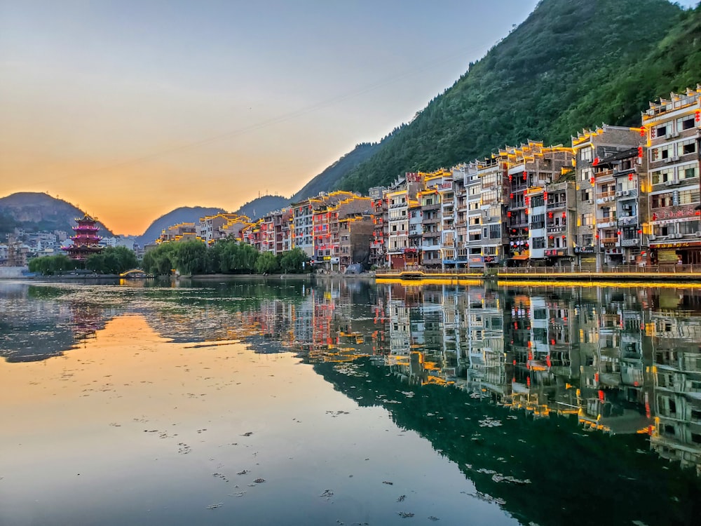 multicolored buildings and houses near body of water viewing mountain during daytime