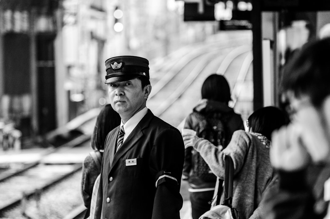 grayscale photography of a policeman on a train station