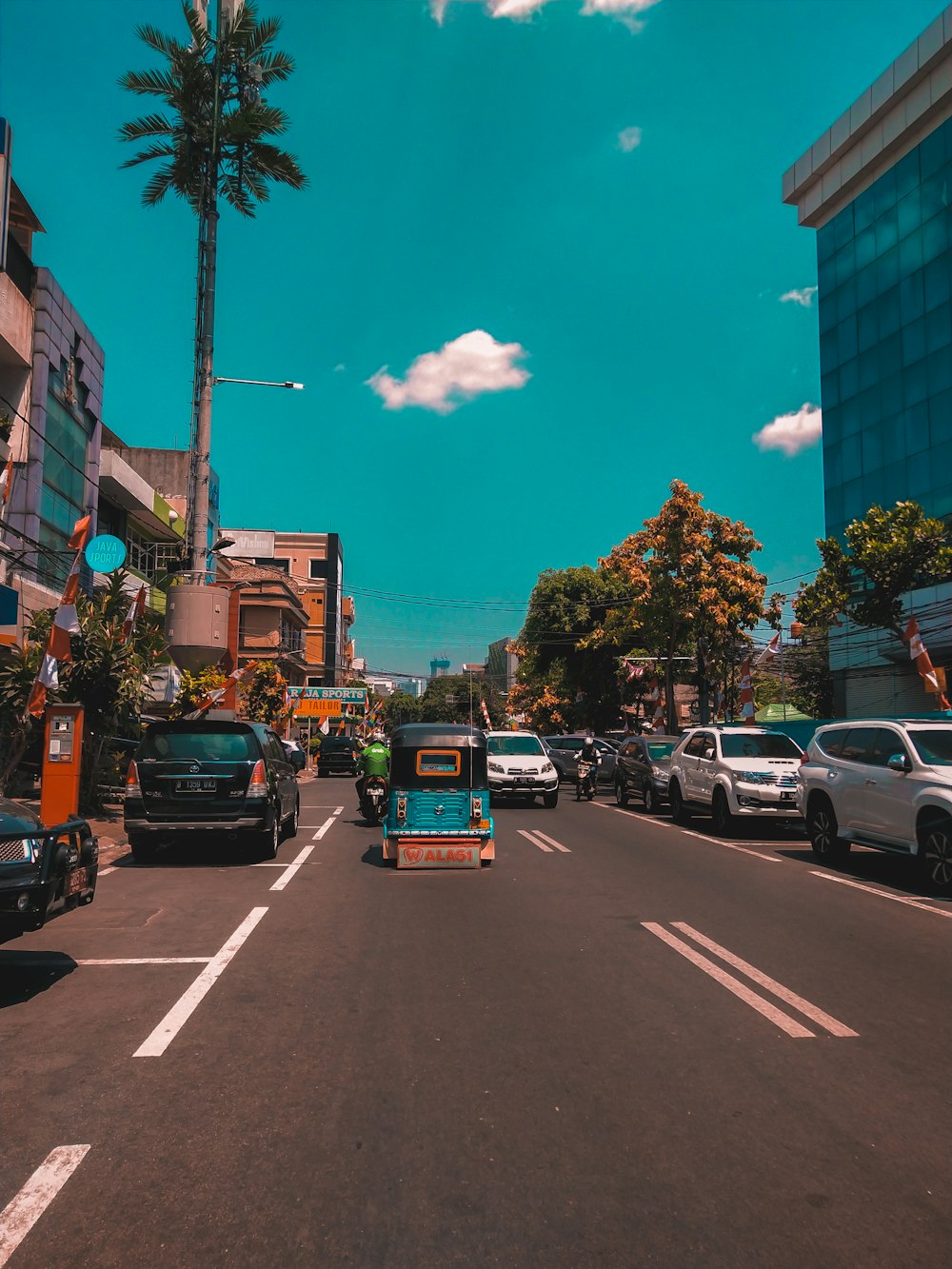 vehicles passing by a city street during daytime