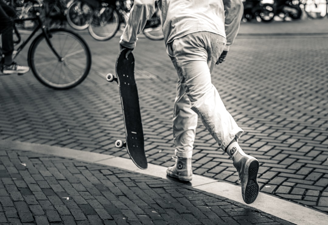 grayscale photography of man playing skateboard