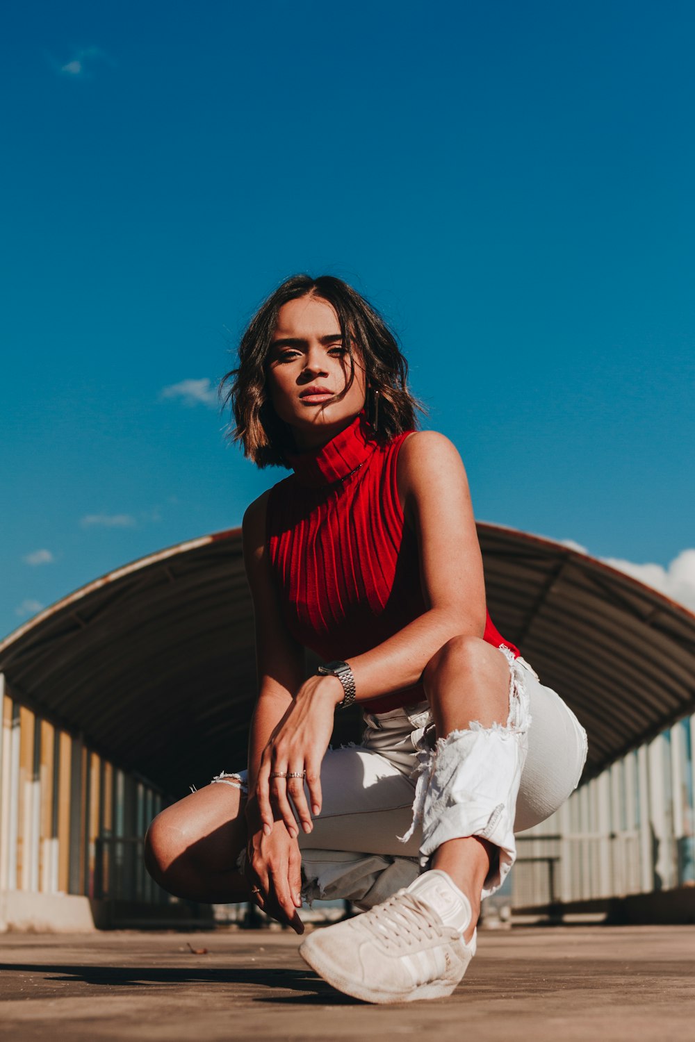 sitting woman wearing red sleeveless shirt during daytime