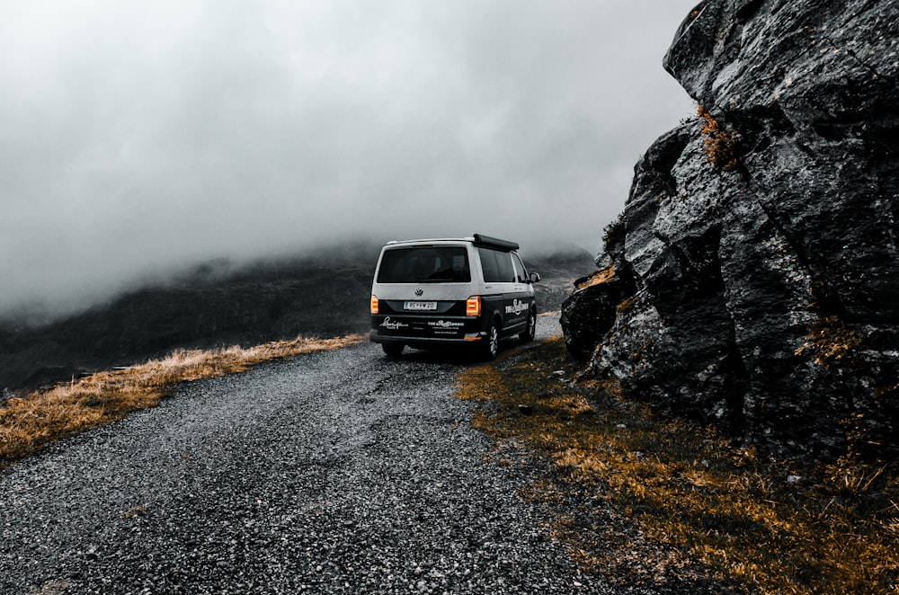 white and blak SUV beside mountain cliff