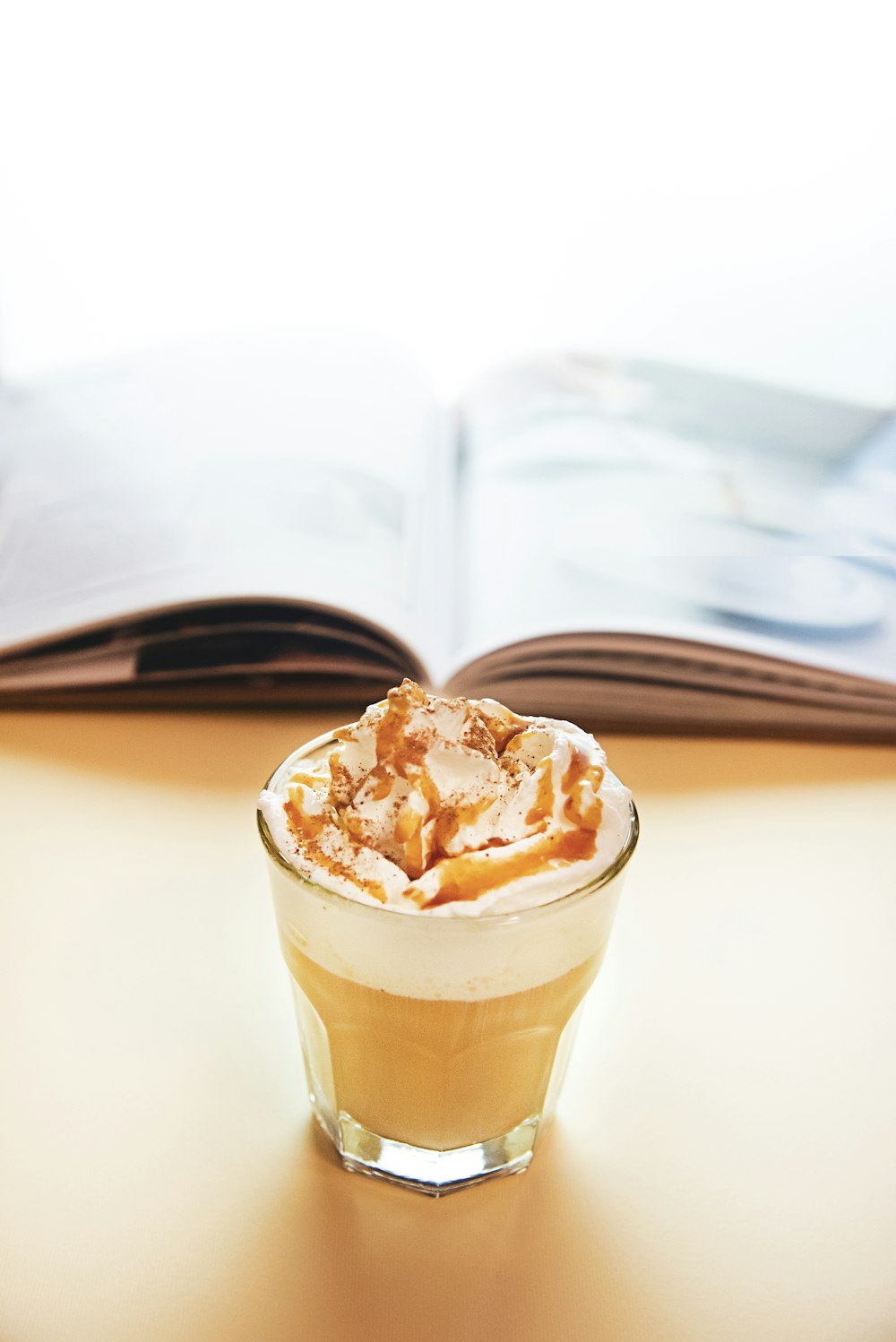 full-filled drinking glass beside opened book