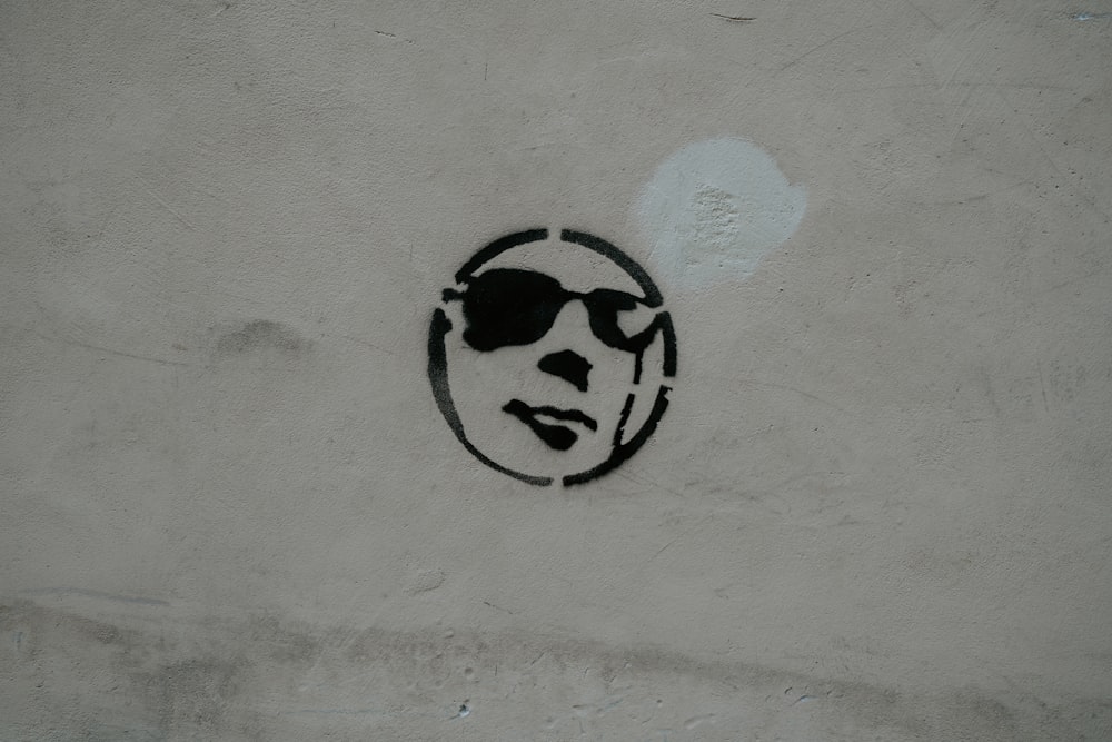 white painted wall with illustration of face wearing glasses