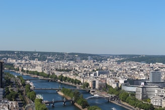 A panoramic view of a city skyline from high above, with rivers and bridges weaving through the urban landscape.