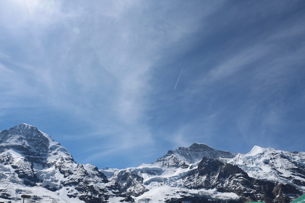 snow covered mountain under cloudy sky