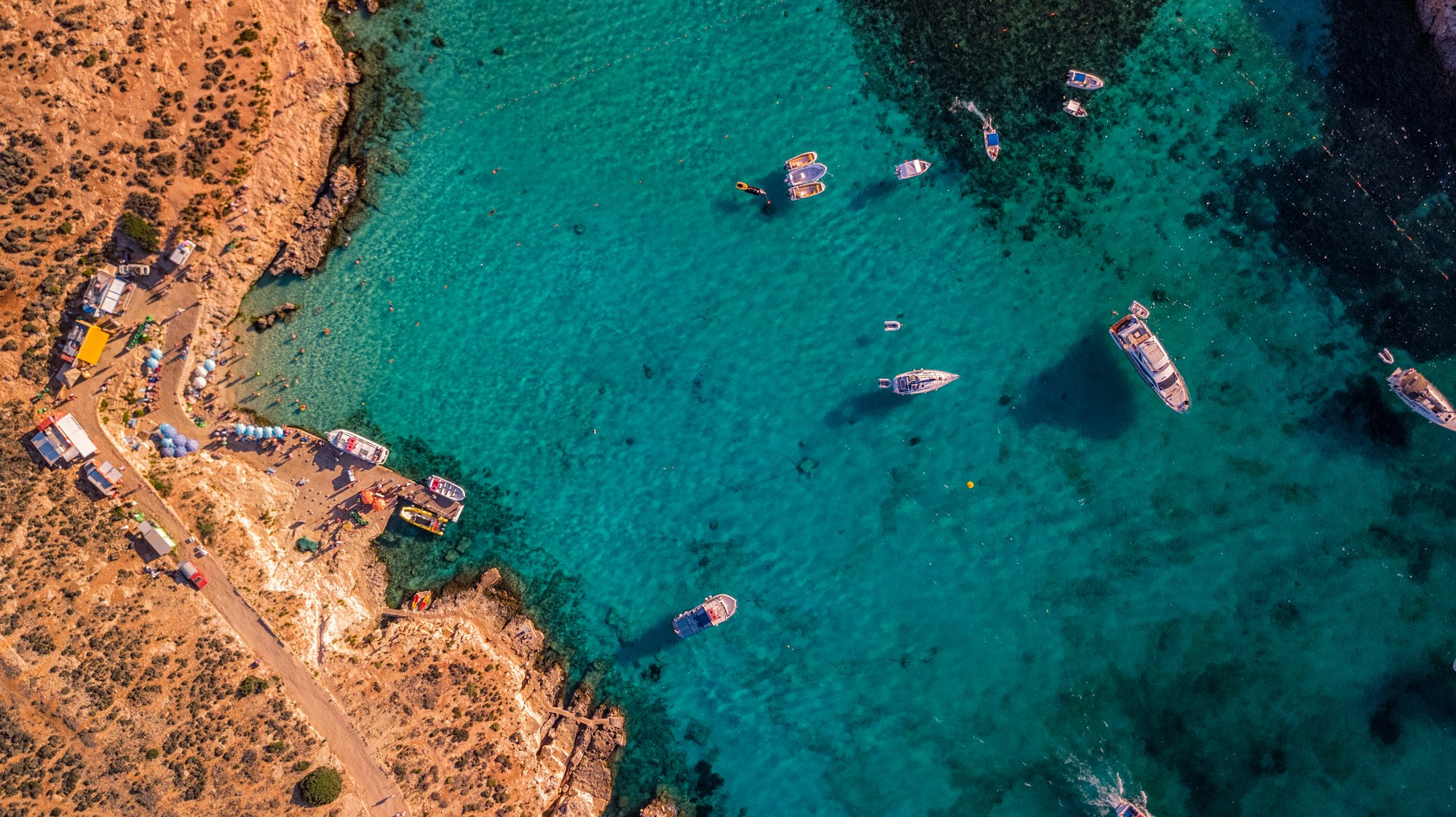 Blue Lagoon, aerial view of blue sea water with boats near island Comino, Malta  Photo by Mike Nahlii / Unsplash