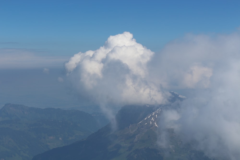 white clouds over mountain during daytime