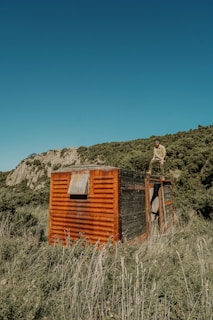 person standing near orange shed during clear blue sky
