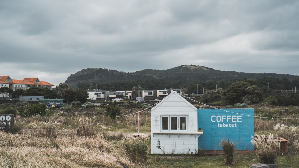 a small white building with a blue sign in front of it