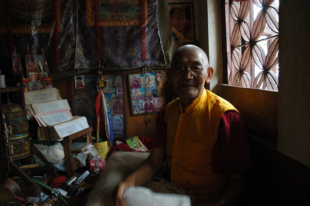 man wearing red top sitting inside house