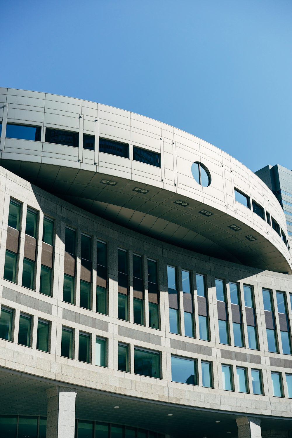 Fotografía de ángulo bajo edificio gris bajo cielo azul claro