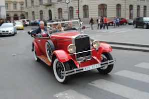 A classic vintage convertible cruising down a city street.