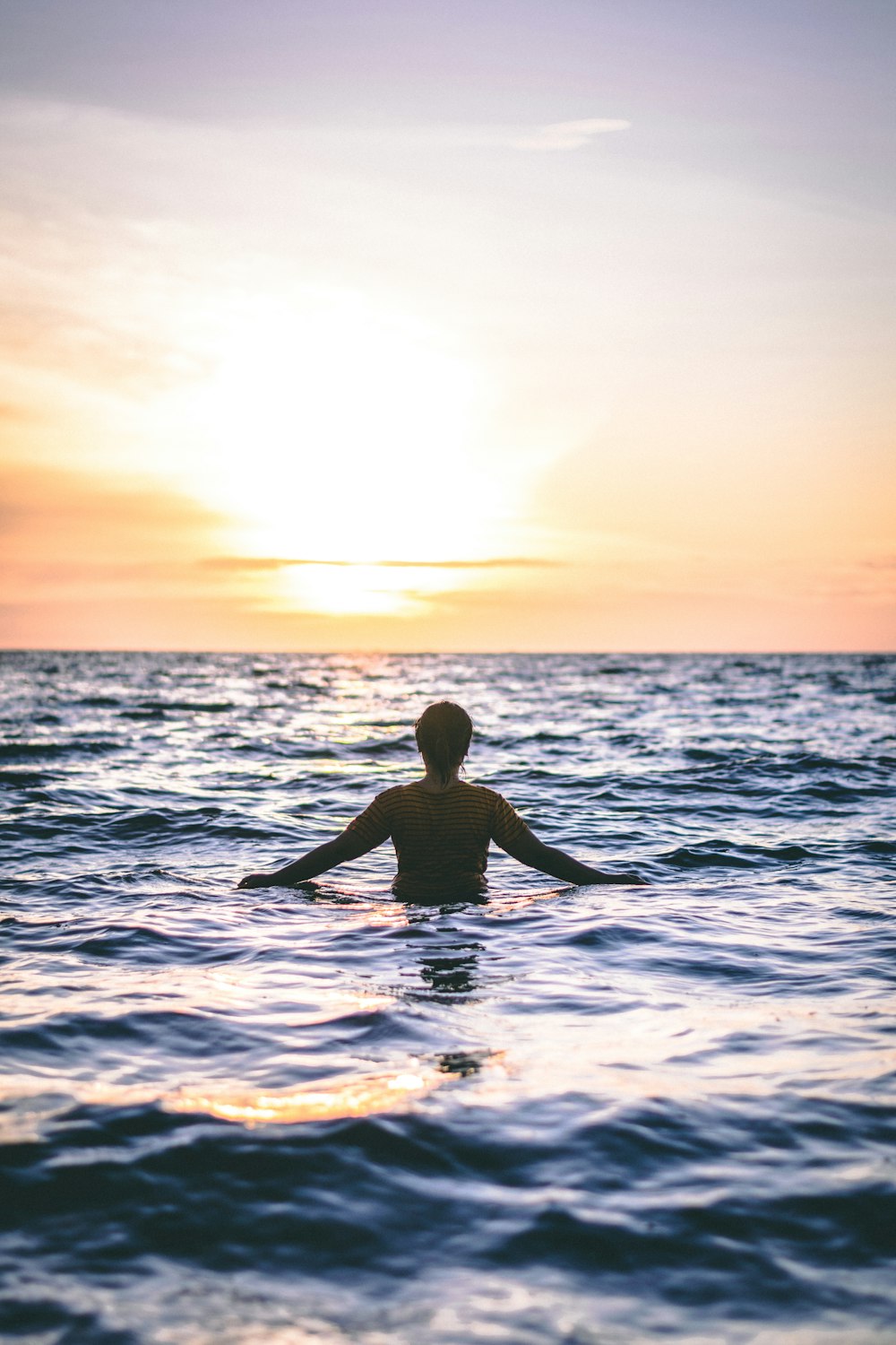 man in the ocean during day