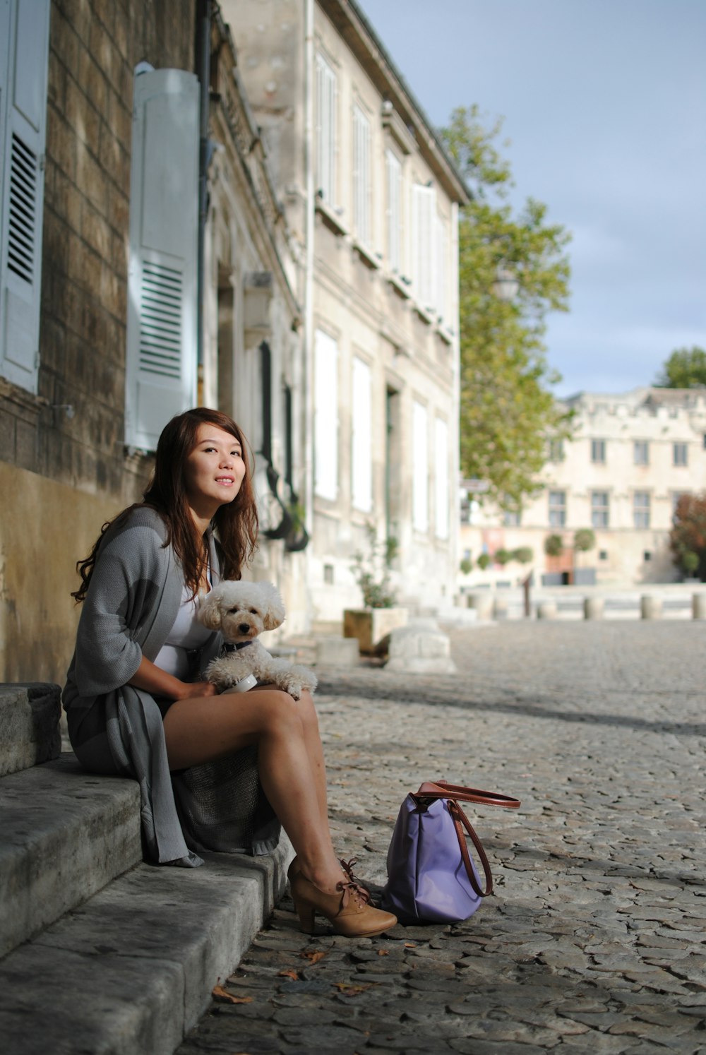 woman sitting on stairs with dog on her lap