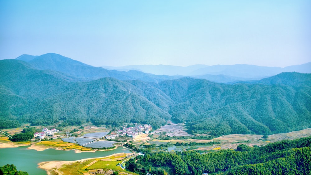 green mountains and body of water