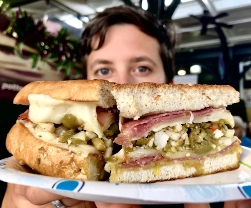 cuban sandwich with person's eyes in the background