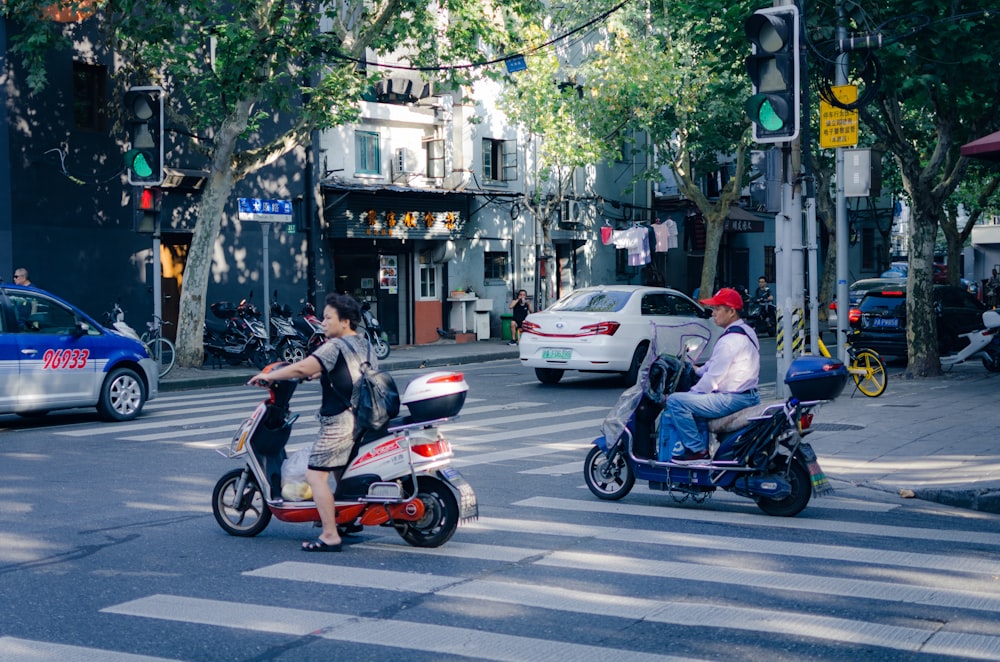 Männer fahren Moto-Scooter auf Fußgängern