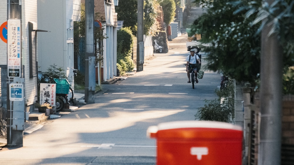 man riding bike near buildings during day