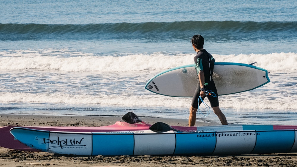 man holding surfboard during daytime