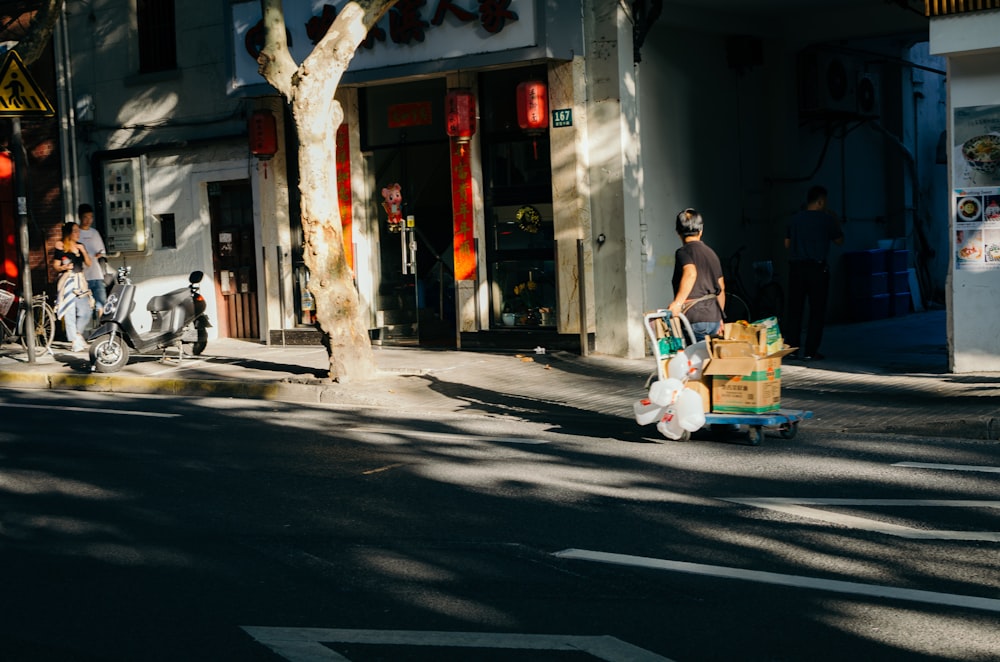 person in black T-shirt holding brown cardboard box