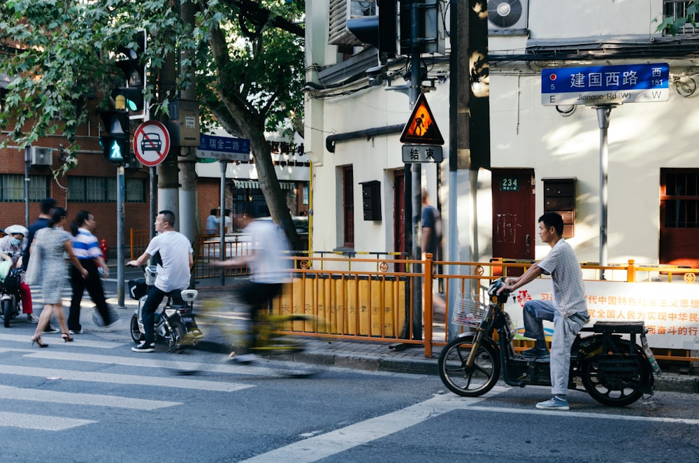 people walking and riding bikes and motorcycles near building during day