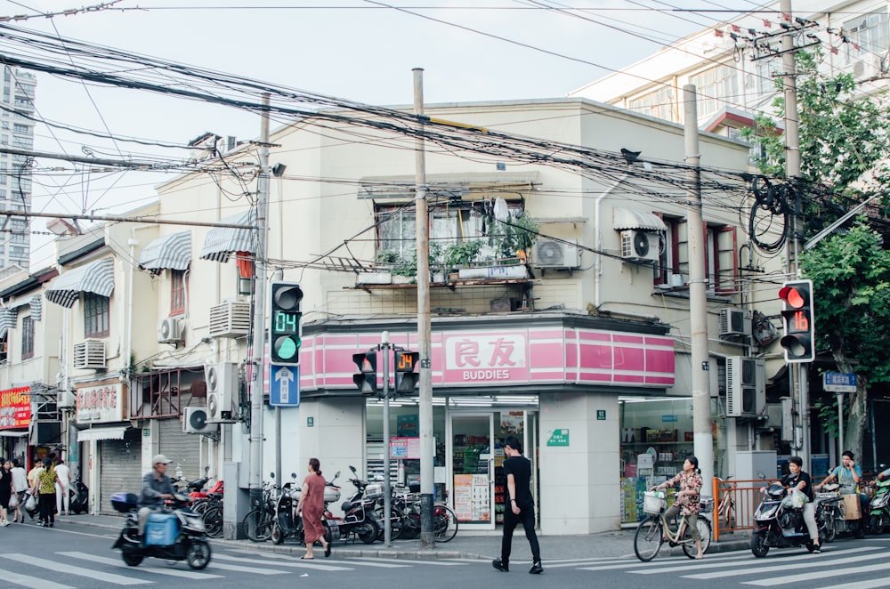 people walking and riding bikes and motorcycles near buildings during day