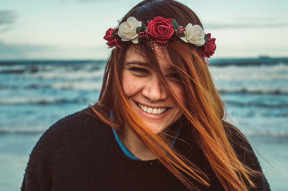 shallow focus photo of woman in black crew-neck shirt wearing red and white floral headband