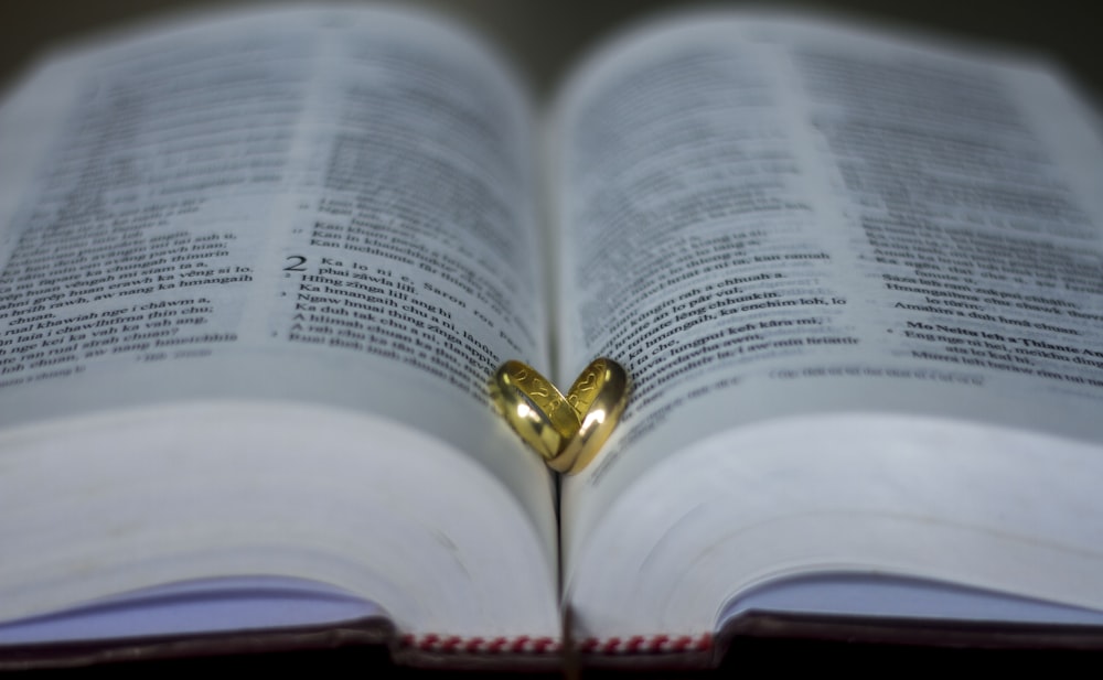 shallow focus photo of gold-colored rings on book