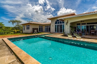 brown framed teal pool under white clouds