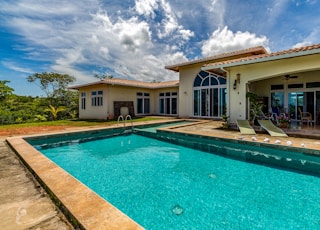 brown framed teal pool under white clouds